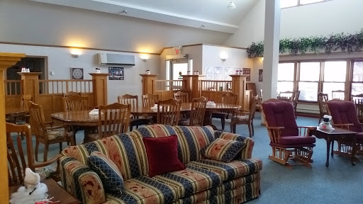 A cozy lounge area featuring a colorful striped sofa and a dining section filled with wooden chairs.