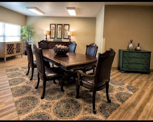 A spacious dining room featuring a wooden table with elegant chairs, complemented by decorative items and an area rug.