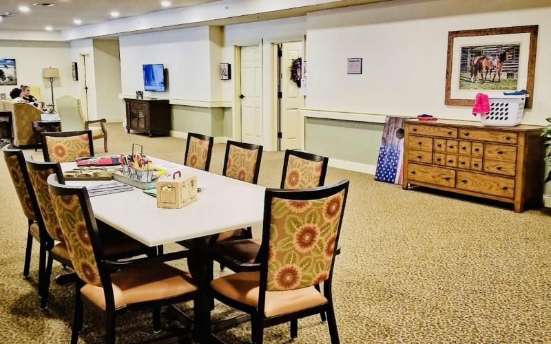 A conference room with a table and decorative chairs arranged for a meeting.