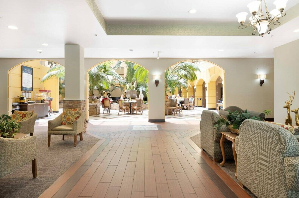 Spacious hotel lobby with elegant furniture and lush greenery.