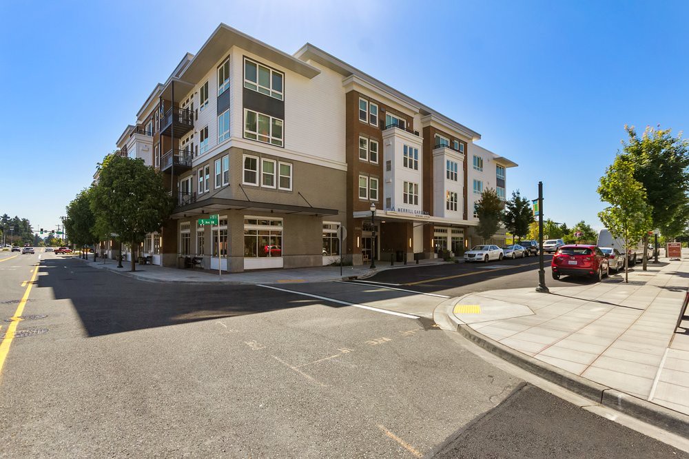 A modern apartment building located on a street corner in an urban residential area.