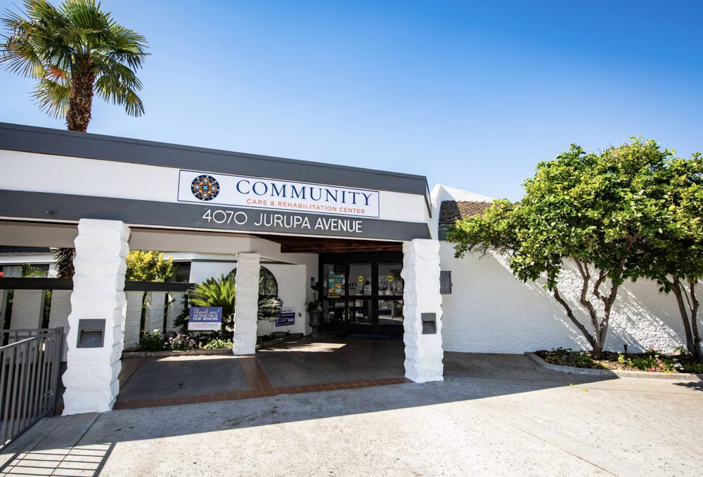 The entrance to a community building with clear signage and surrounding greenery.