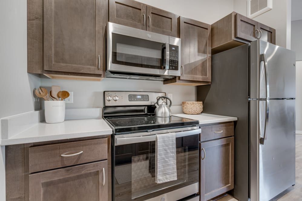A modern kitchen with stainless steel appliances and dark wooden cabinets.