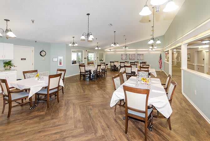 A spacious and well-lit dining room with neatly arranged tables and chairs.