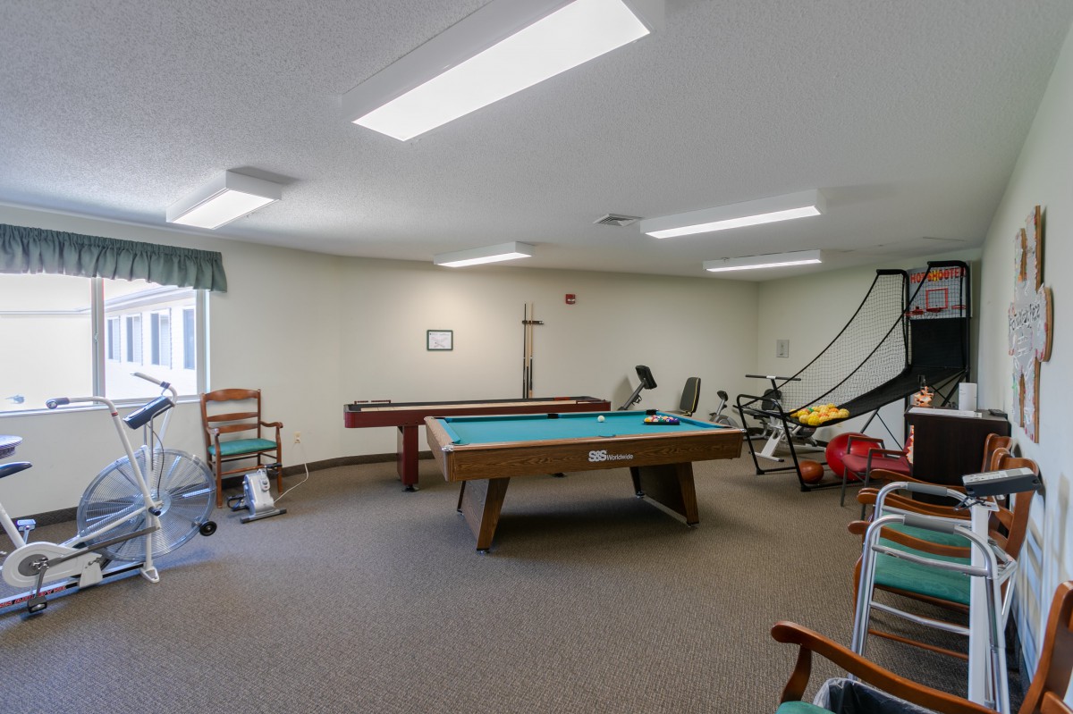A game room featuring a pool table and exercise equipment.