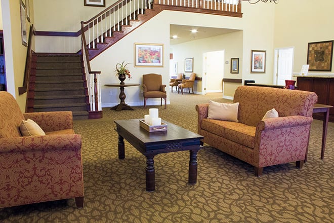 A cozy living room with comfortable seating and a decorative staircase.