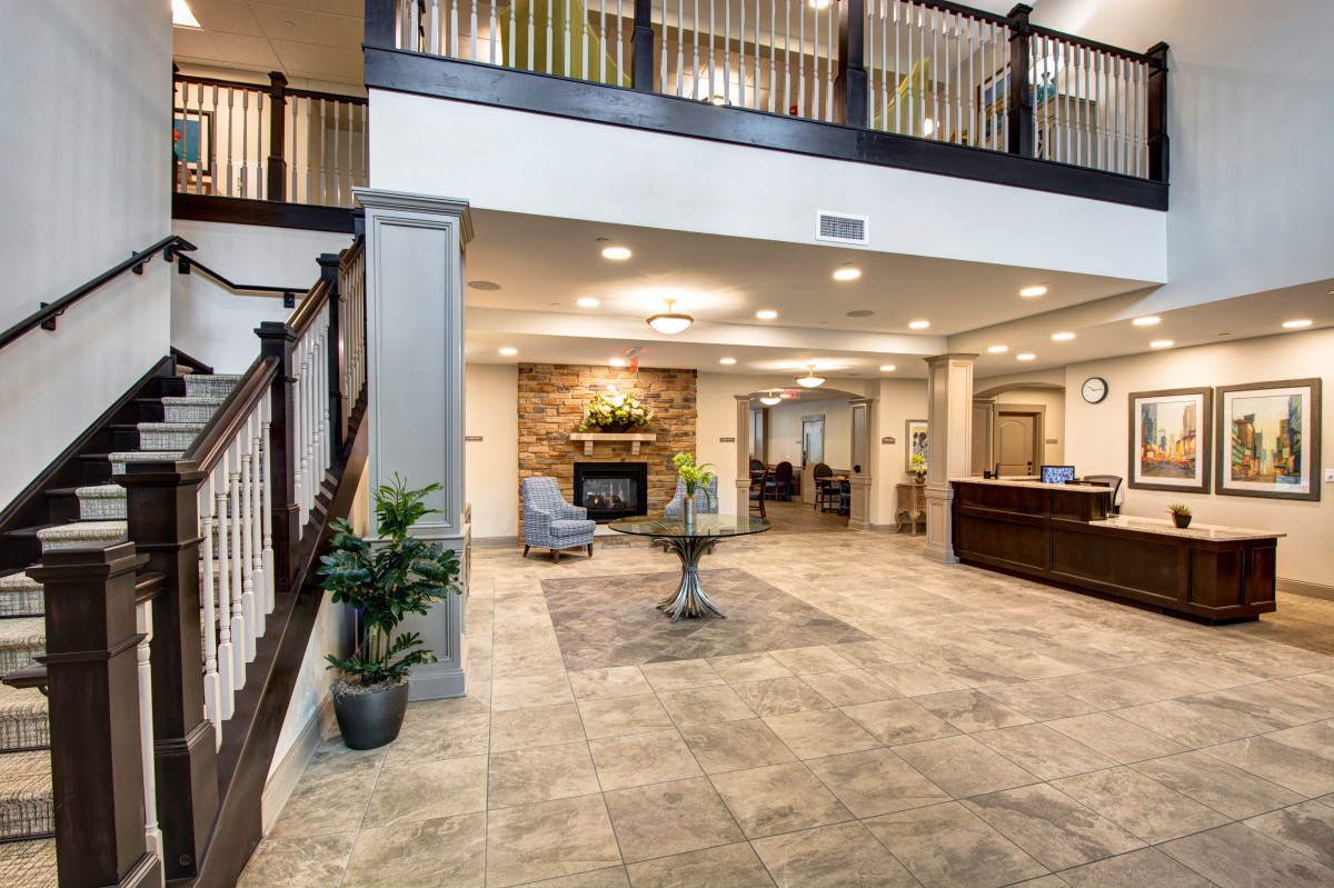 A spacious lobby with a reception desk, seating area, and decorative plants.
