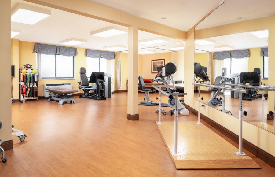A rehabilitation therapy room equipped with various exercise machines and equipment.