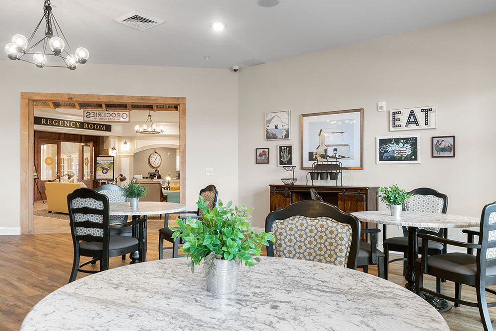 A cozy dining area with elegant decor, featuring tables, chairs, and green plants.