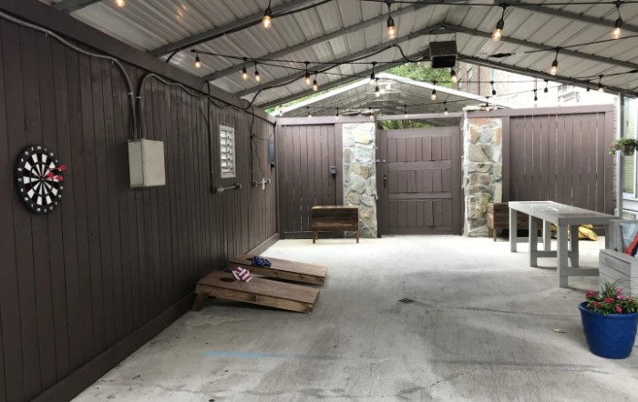 A well-lit garage interior with cornhole boards on a concrete floor.