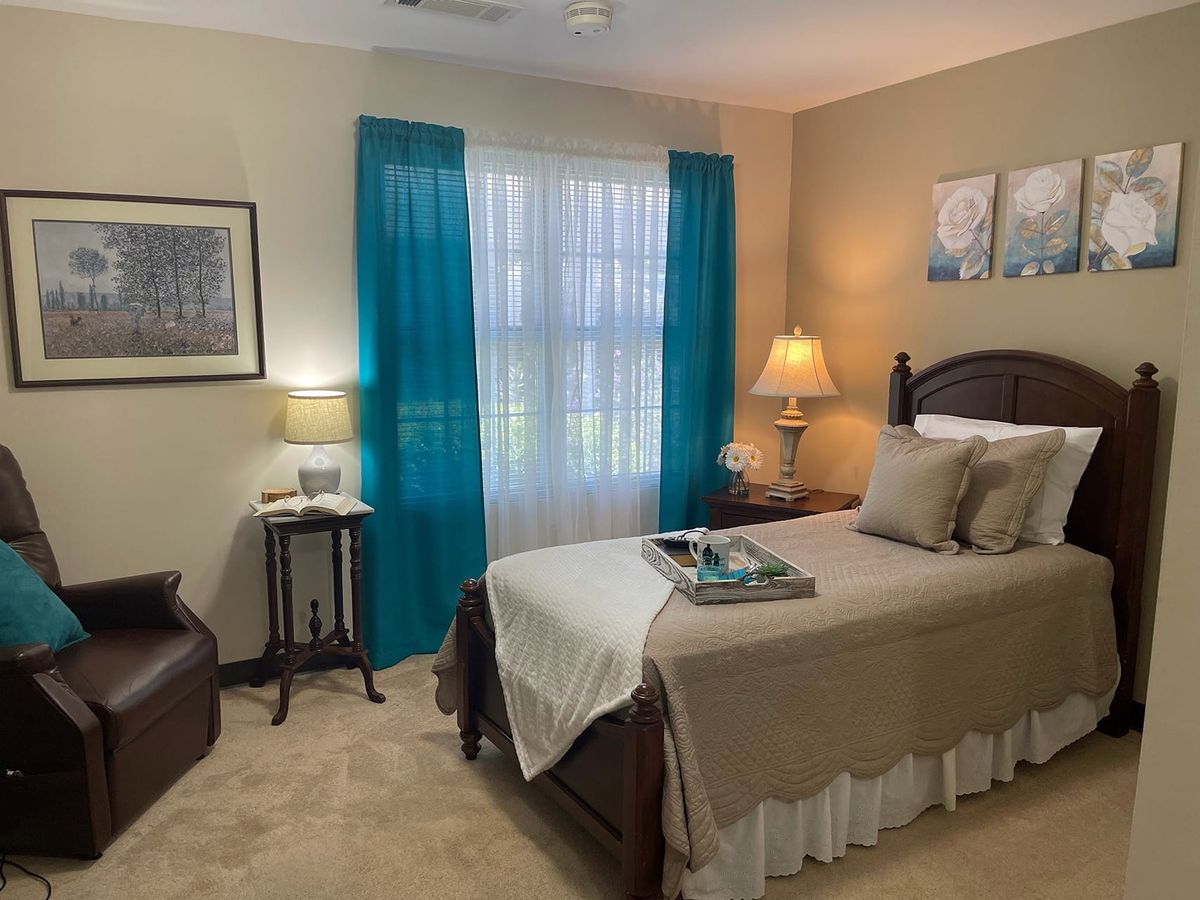 Cozy bedroom with teal curtains and warm lighting.
