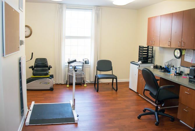 A well-organized office space featuring exercise equipment and a work station.