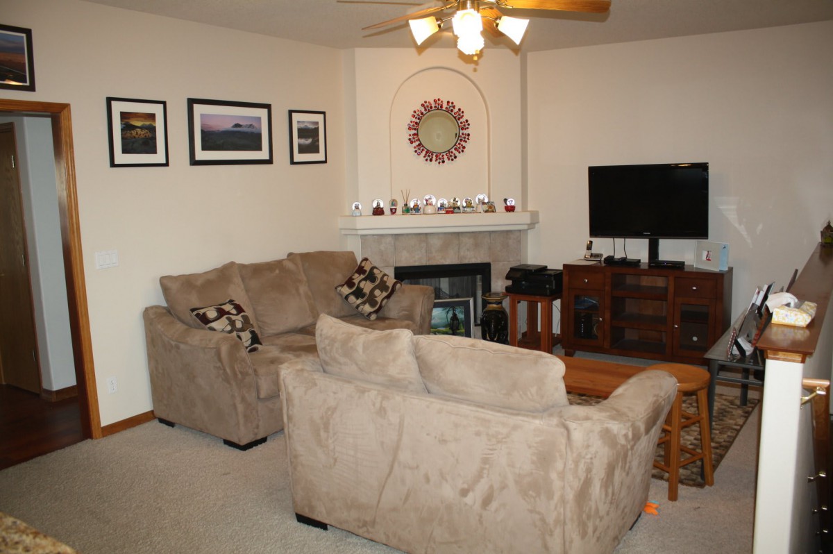 A cozy living room with sofas, a fireplace, and a TV.