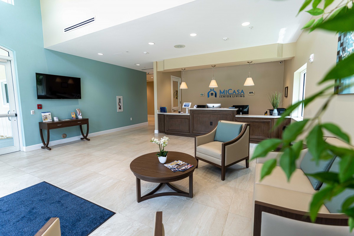 A modern lobby featuring a reception desk and comfortable seating area.