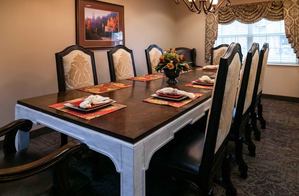 A well-decorated dining room with a wooden table set for dinner.