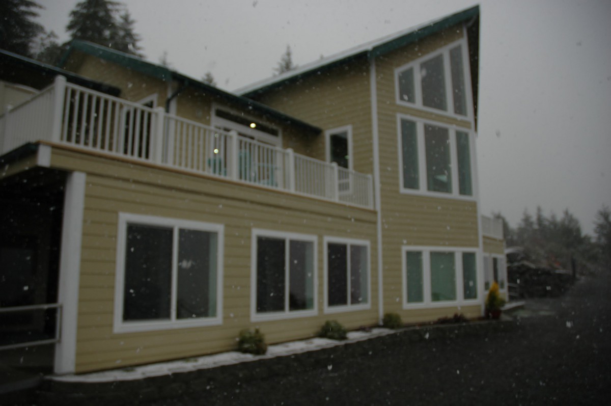 A modern two-story house with large windows and a balcony.