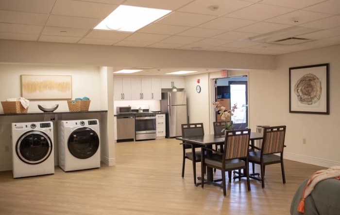 A modern open-plan kitchen and dining area with appliances and seating.