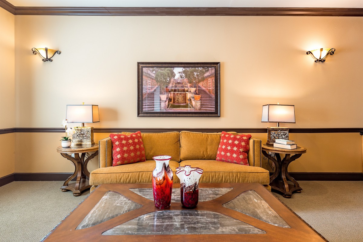A cozy living room with a yellow sofa, red cushions, and elegant decor.
