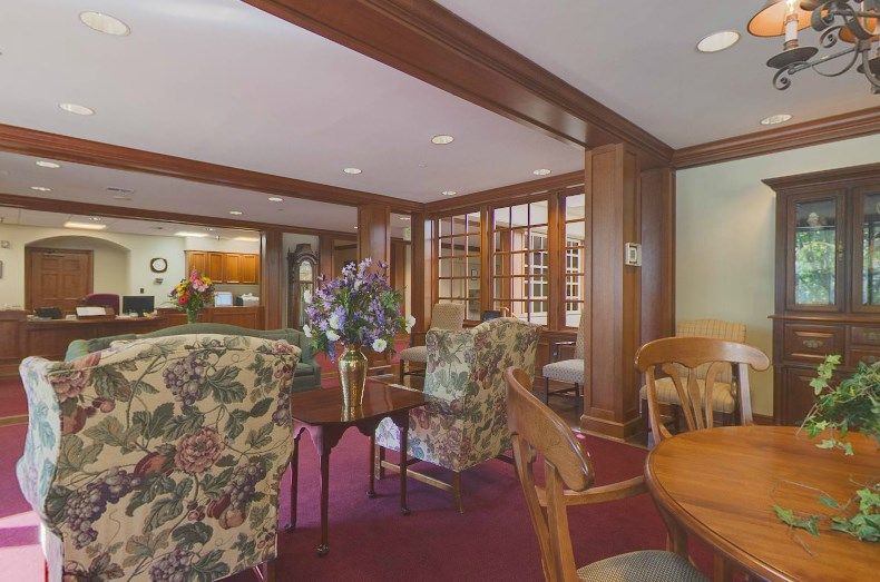 A cozy lobby area featuring floral upholstered chairs and rich wood paneling.