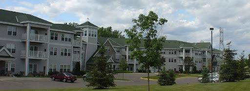 A multi-story building surrounded by trees in a scenic landscape.