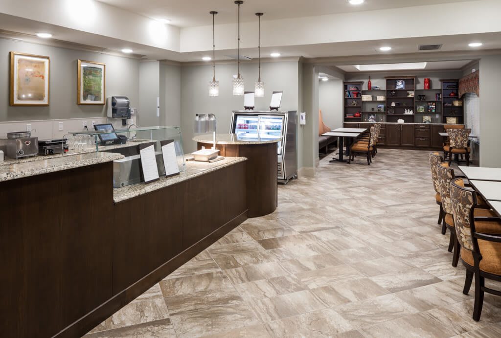 A modern hotel lobby with a reception desk and waiting area.