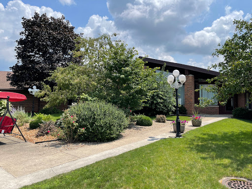 A serene outdoor space featuring lush greenery and a pathway leading to a building.