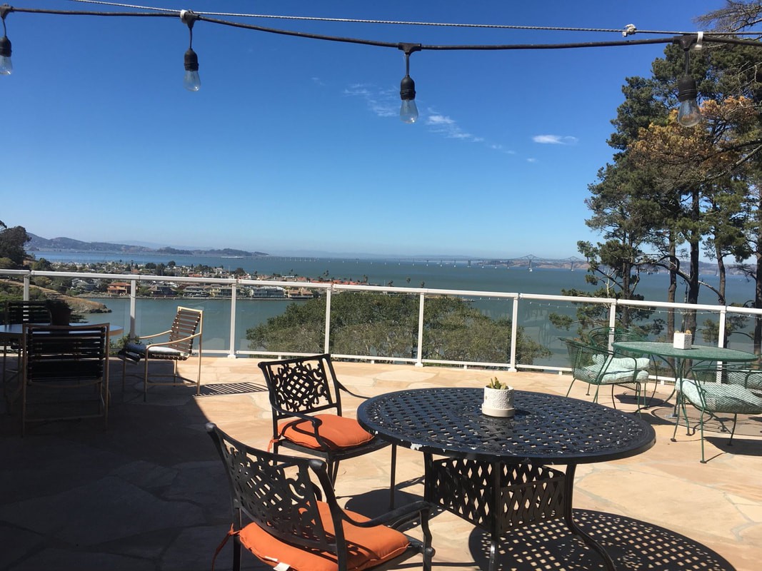 A scenic patio with outdoor seating offering a view of the ocean.