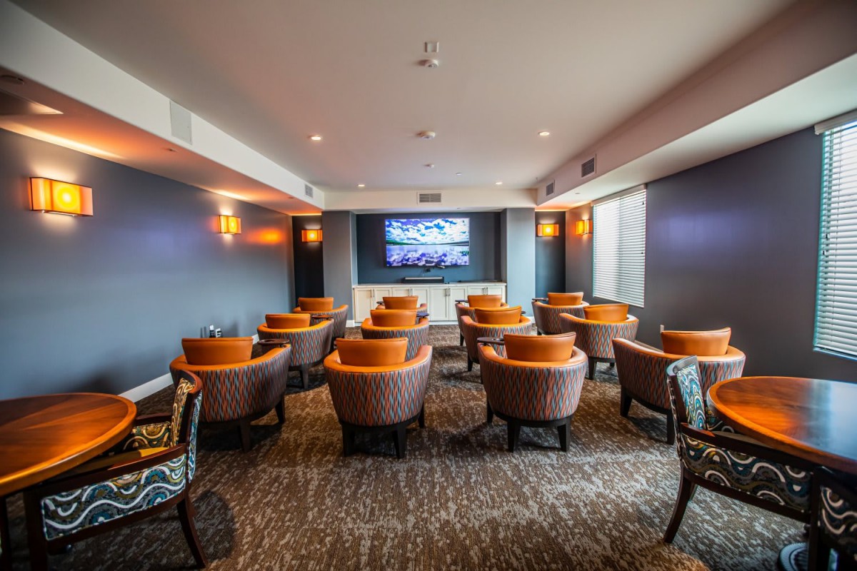 A modern home theater with arranged seating facing a large screen.