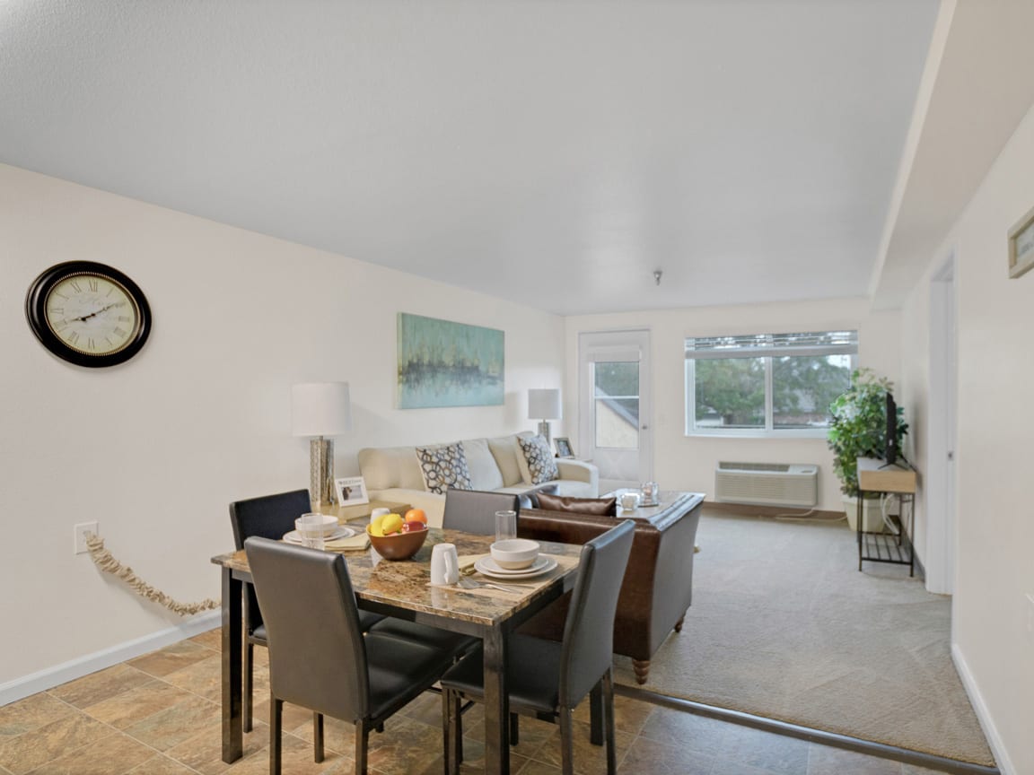 A modern living and dining area with minimalist decor and ample natural light.