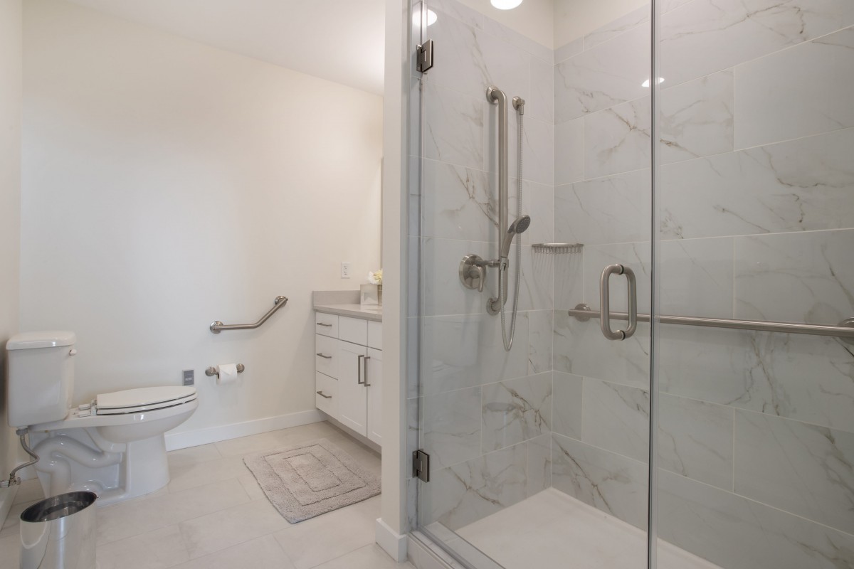 A modern bathroom featuring a glass-enclosed shower, sleek vanity, and minimalist design.