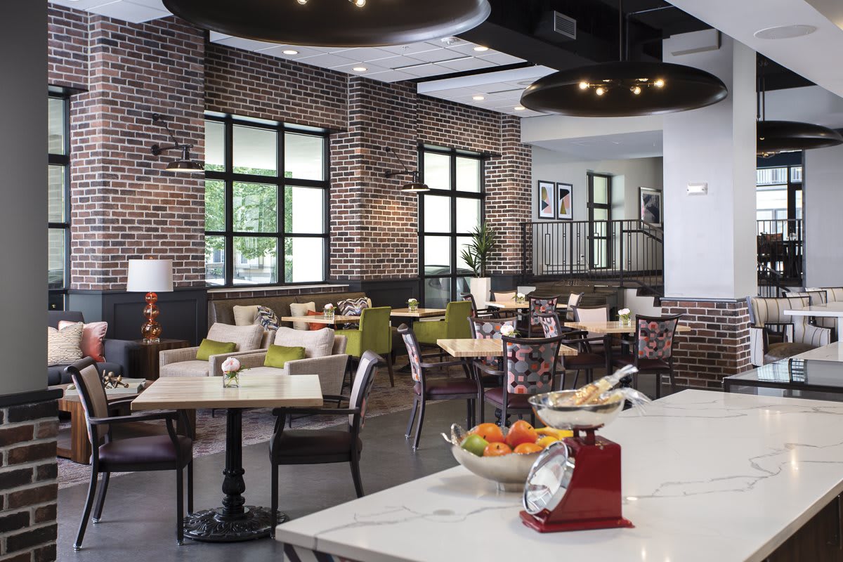 A modern restaurant interior with stylish furniture and brick walls.