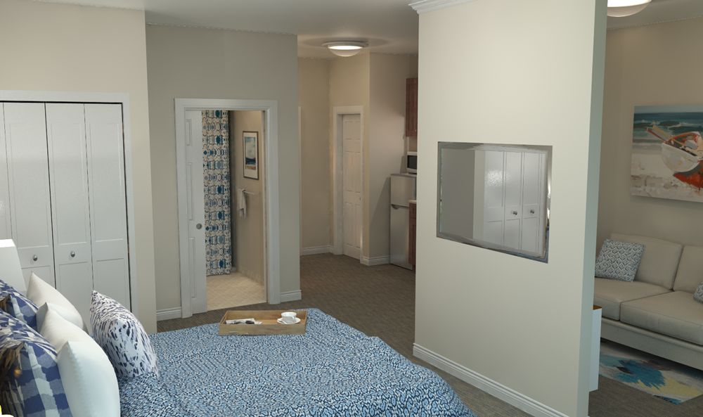 A modern and cozy bedroom in an apartment with a neatly arranged bed and view toward the bathroom and kitchenette.