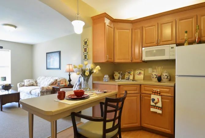 A cozy kitchen with wooden cabinetry and a small dining area.