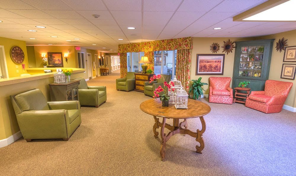 A cozy lobby area featuring comfortable seating, a central table with decorative items, and warm lighting.