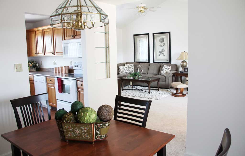 An open space interior featuring a kitchen, dining table, and adjacent living room with modern decor.