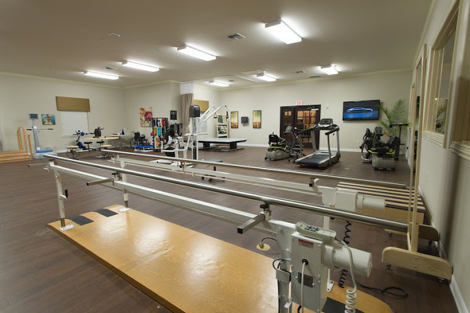 A rehabilitation center equipped with parallel bars and exercise machines.