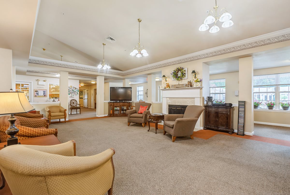 A spacious and well-lit living room featuring comfortable seating, a fireplace, and elegant home decor.