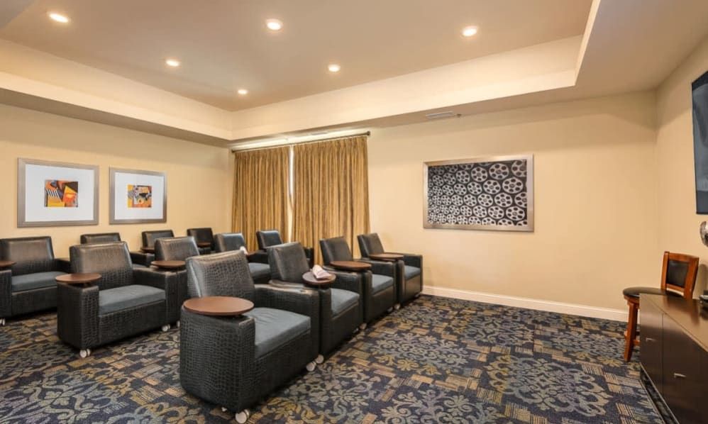 A small theater room with comfortable seating and a large screen.