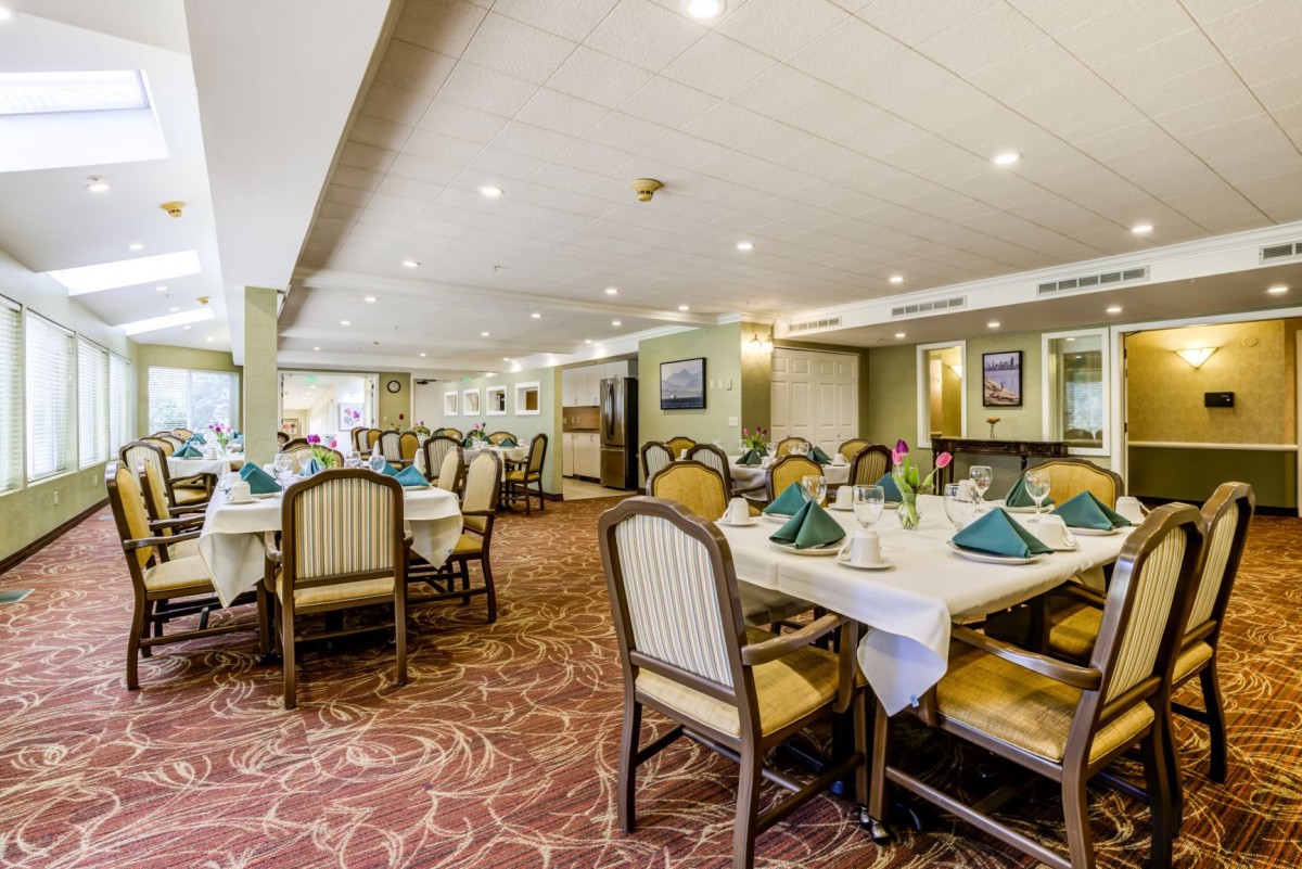 A spacious restaurant dining area with elegantly set tables and comfortable seating.