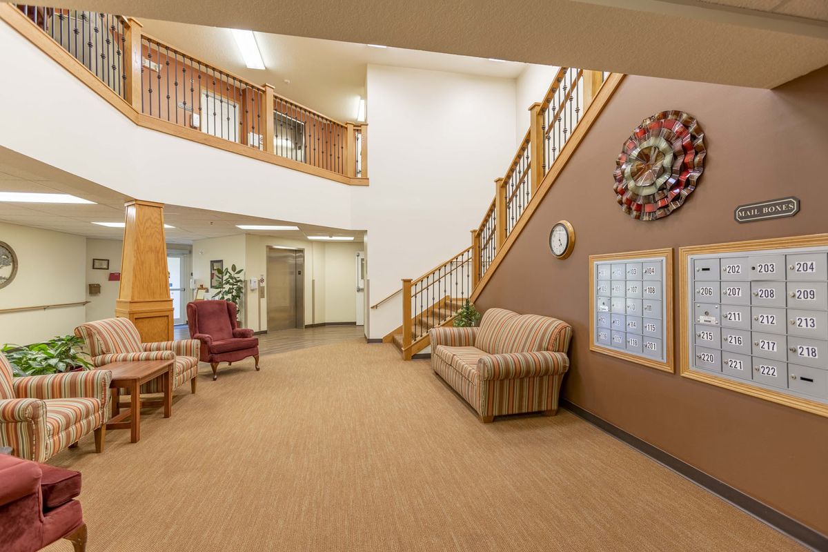 A cozy lobby with seating and a staircase leading to the second floor.