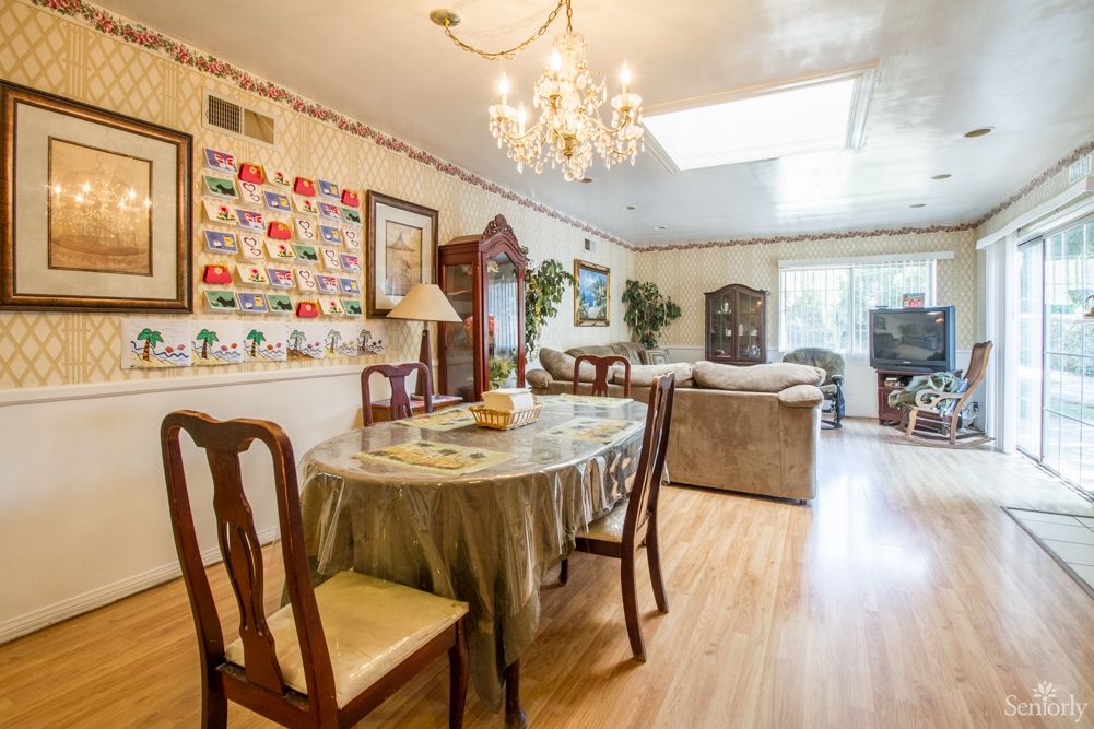 A cozy dining and living area with elegant furnishings and a chandelier.