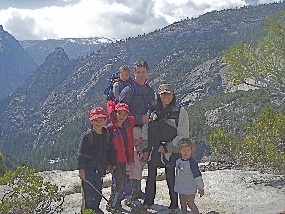 A family hiking in the mountains enjoying a scenic view.