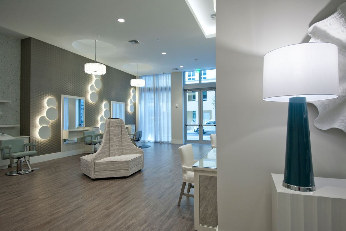 A modern and elegantly designed lounge area with stylish furniture and ample natural lighting.