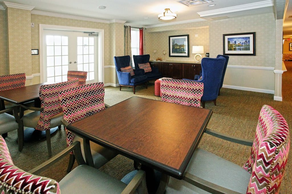 A cozy living room with a table and chairs, featuring comfortable seating and elegant decor.
