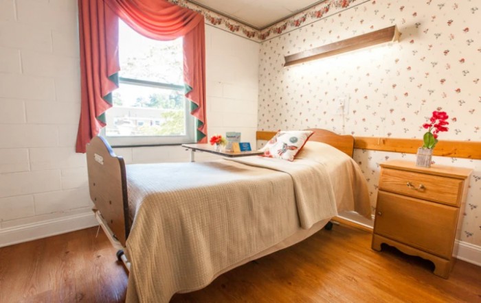A cozy hospital room with a bed and window featuring elegant curtains.