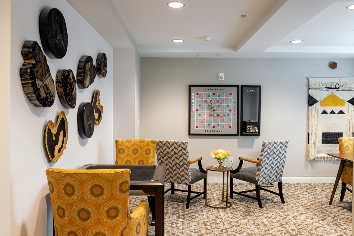 A stylish living room with modern decor, featuring patterned chairs and wall art.