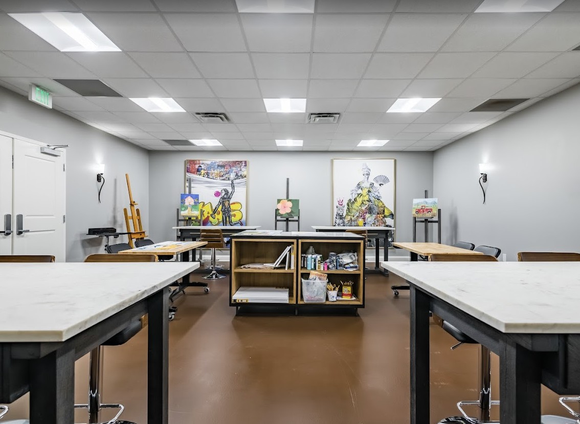 An art classroom equipped with easels, tables, and various art supplies.
