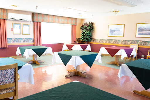 A spacious dining area featuring neatly arranged tables with colorful tablecloths.