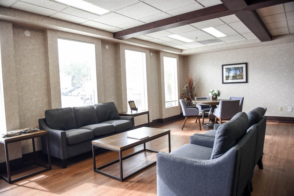 A modern office lounge area with comfortable seating and large windows.