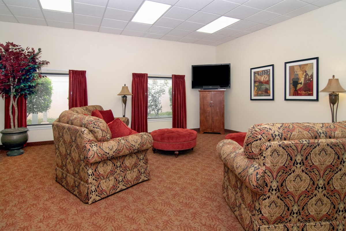 A cozy living room with sofas, a television, and warm decor.